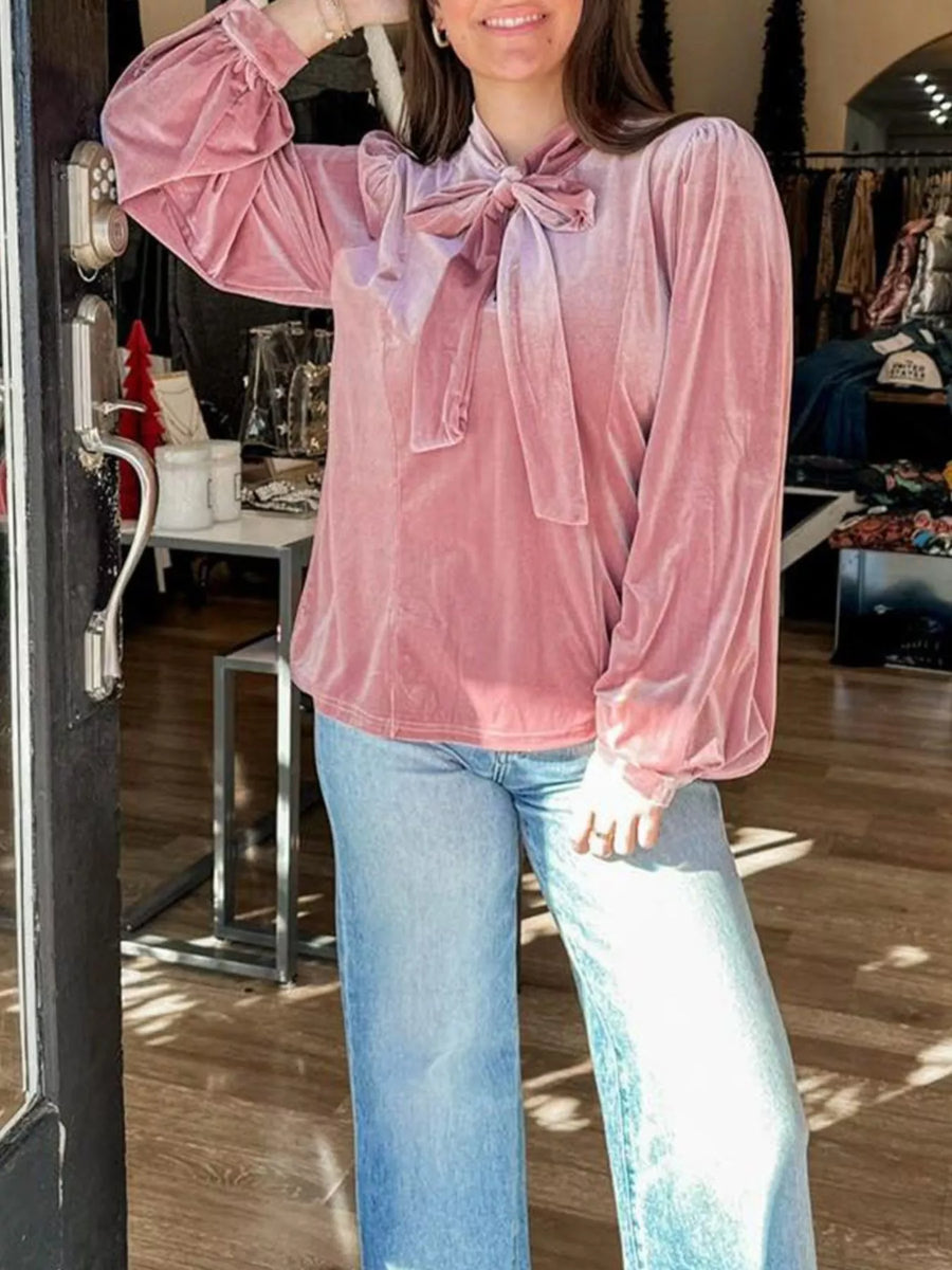 Dusty pink velvet blouse with tie-neck and puff sleeves, styled with jeans.