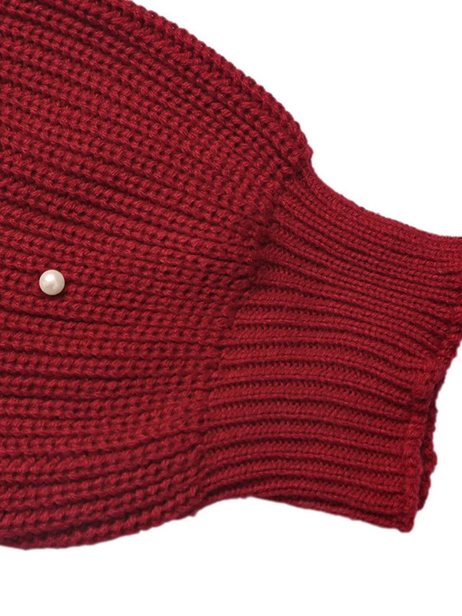 Red acrylic knit cardigan with pearl embellishment and ribbed cuffs.