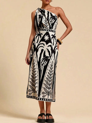 Black and white tropical print one-shoulder midi dress with defined waist and side slit.