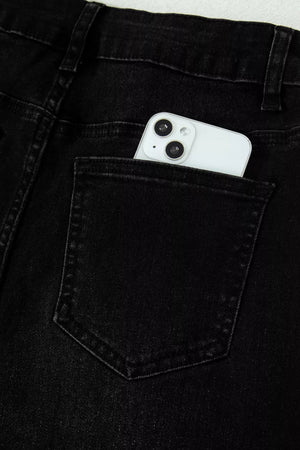 Black high-waisted cropped jeans with raw hem detail, phone in back pocket.