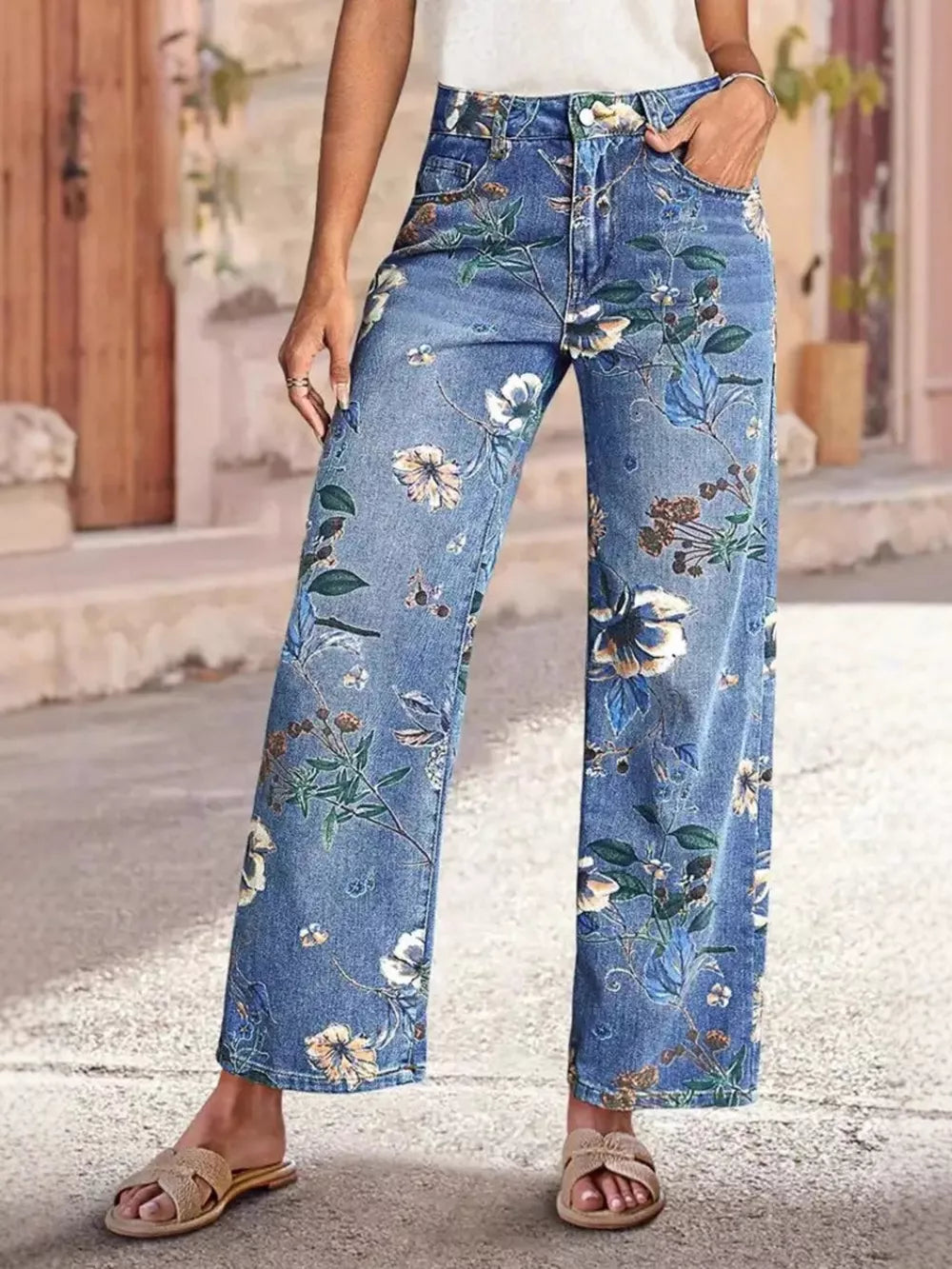 Light blue denim wide-leg jeans with a floral print and embellishments.