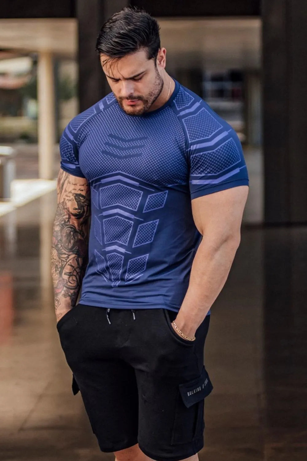 Blue performance tee with geometric detail, short sleeves, crew neck.