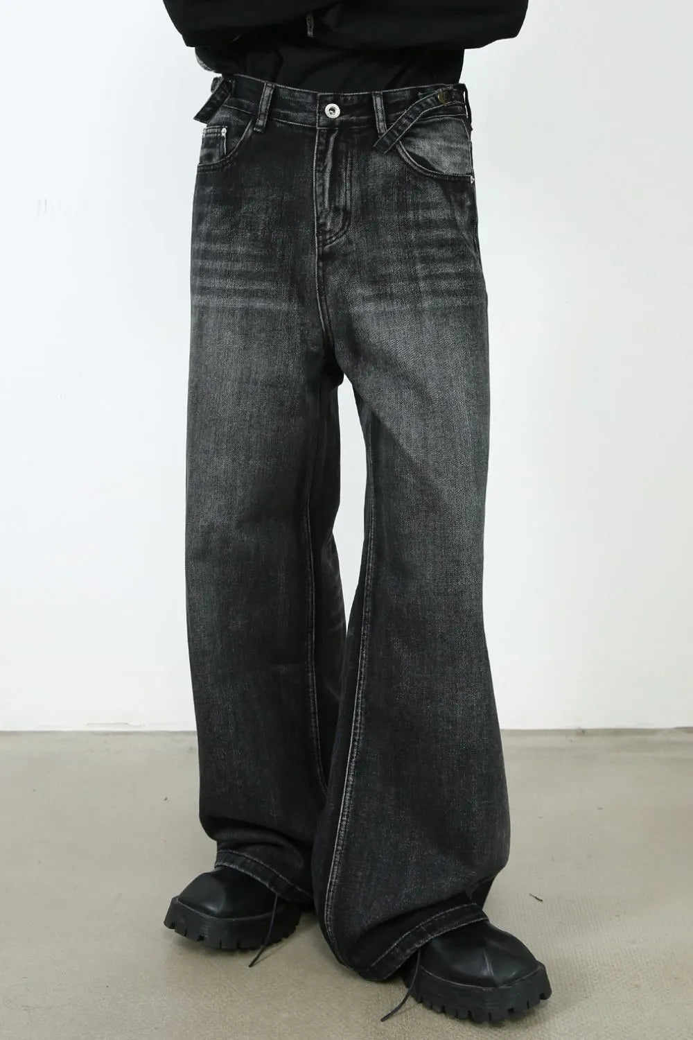 Dark wash denim flared trousers with a high waist and belt detail.