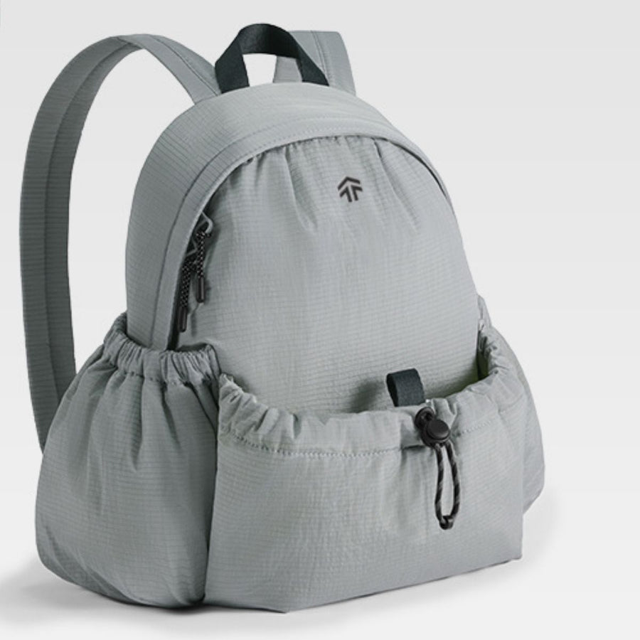 Gray lightweight nylon drawstring backpack with cinched side pockets and a zippered front pocket.