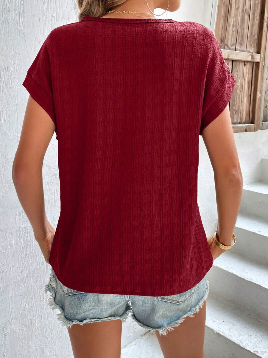 Burgundy woven texture cap-sleeve blouse with a relaxed fit.