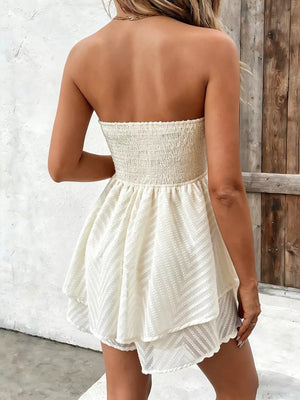 Ivory ruffled tube mini dress with smocked bodice and chevron textured tiered skirt.