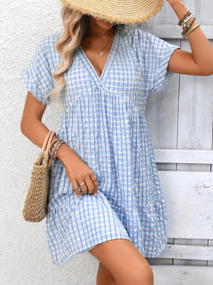 Light blue plaid v-neck mini dress with short sleeves and tiered skirt.