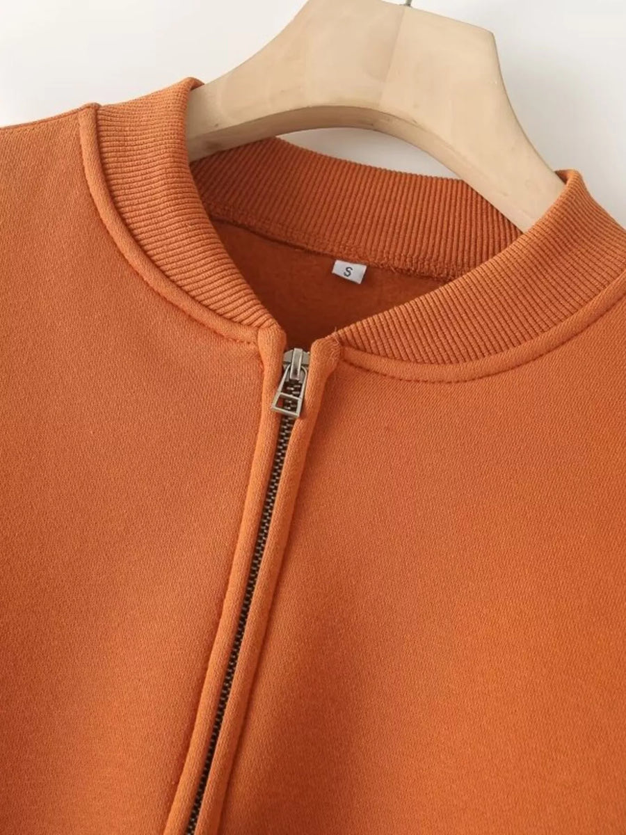 Orange zip-up casual top with ribbed collar and cuffs