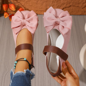 Pink textured round toe flats with bow detail and brown strap.
