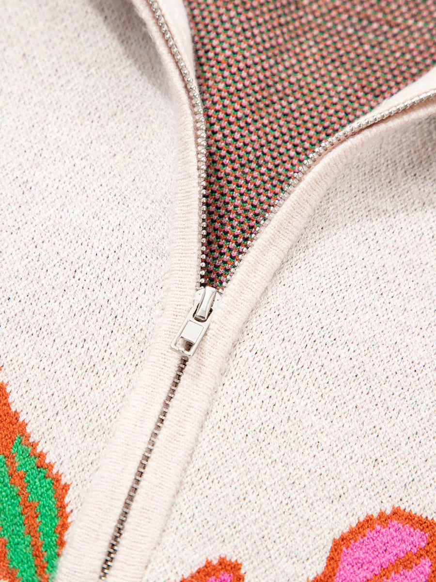 Knit quarter zip sweater with floral pattern, stand neck, and zipper detail.