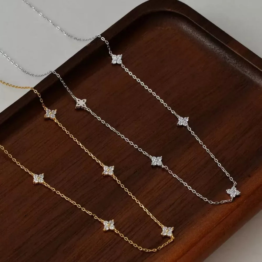 Delicate sterling silver necklaces with clover charms in gold and silver finishes.