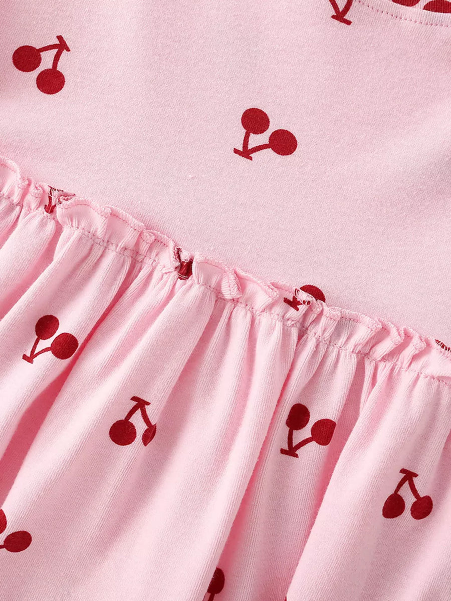 Children's pink short sleeve dress with allover cherry print and ruffled hem.