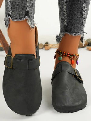 Black textured suede mules with buckle detail and cork sole.