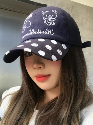 Navy baseball cap with white polka dot brim and bear graphic