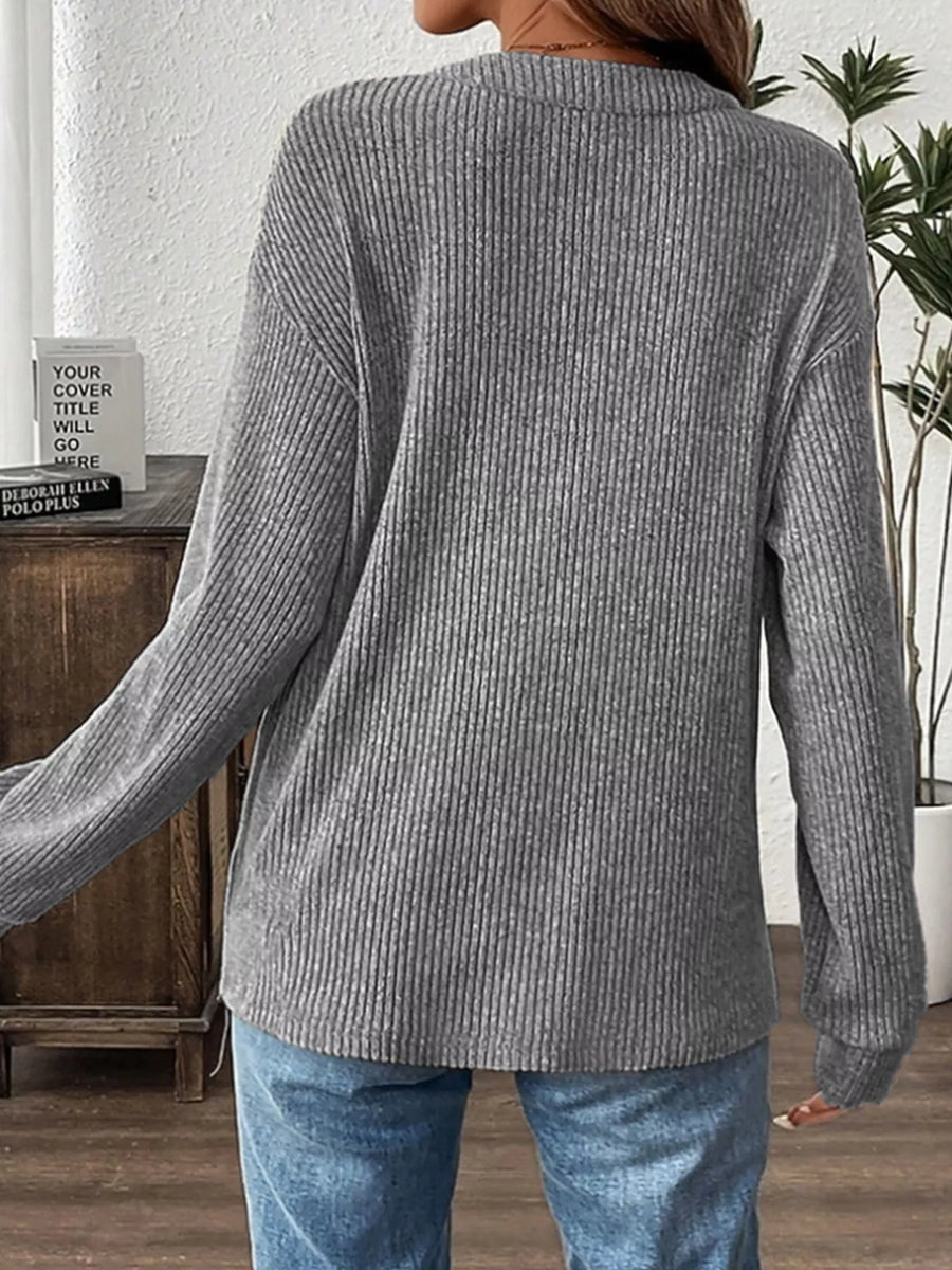 Gray ribbed long-sleeve top with button detail, worn with jeans.