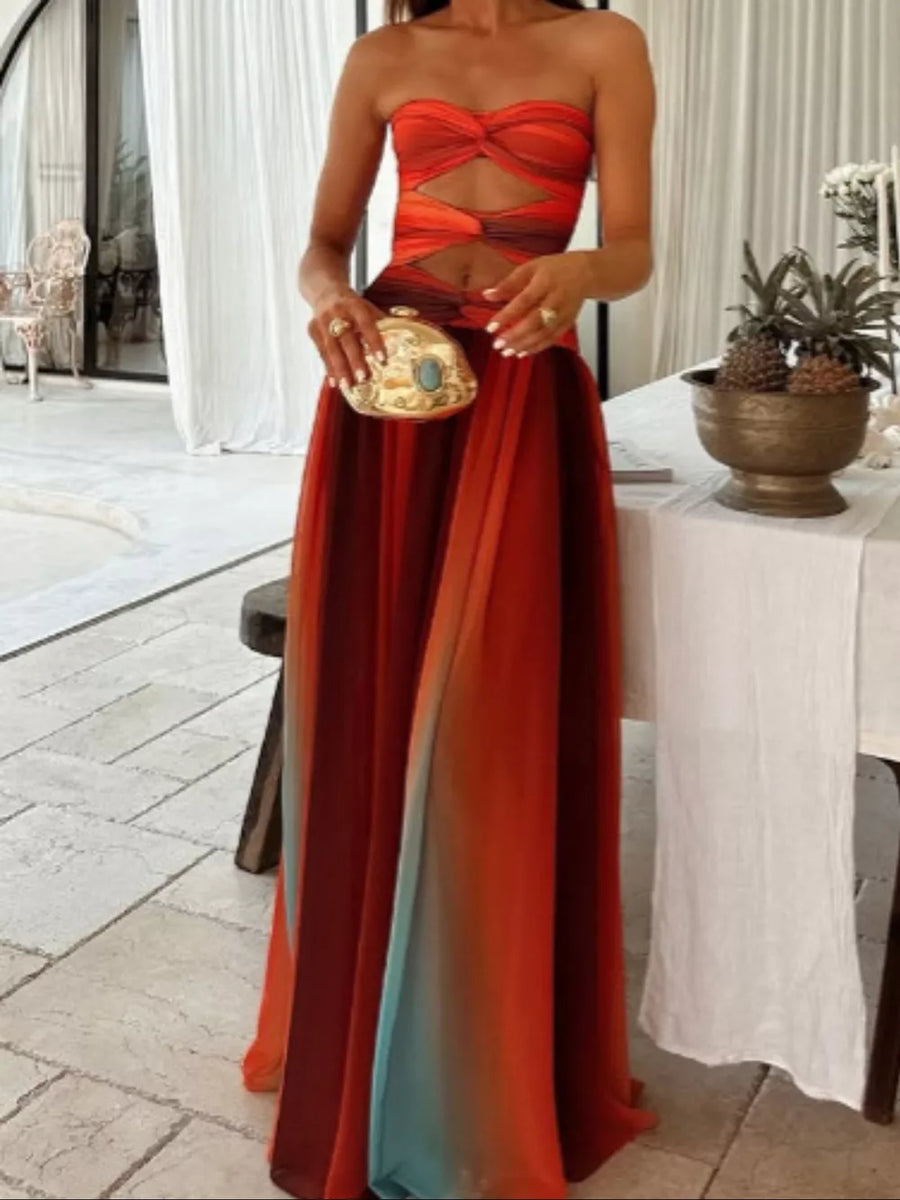 Strapless ombre maxi dress with twisted bodice cutout and flowing skirt.