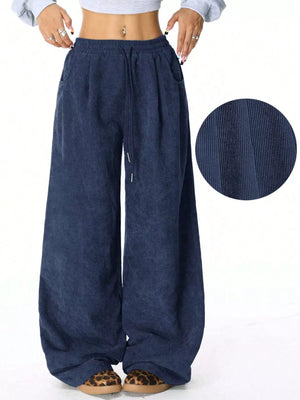 Relaxed blue corduroy drawstring pants with wide legs and pockets.