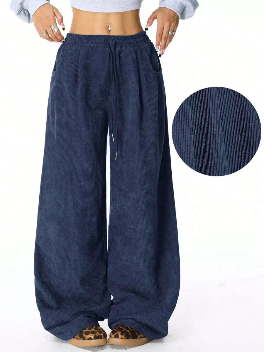 Relaxed blue corduroy drawstring pants with wide legs and pockets.