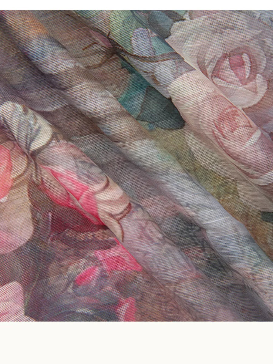 Pastel floral print sheer fabric dress detail with soft pink roses and green leaves.