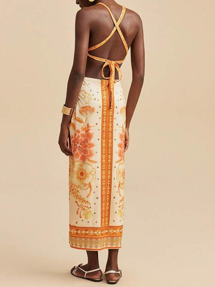 Backless maxi dress with floral print, orange and cream colors, and crisscross straps.