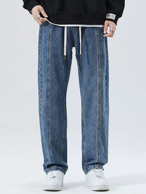 Men's light blue 100% cotton loose-fit jeans with drawstring and vertical seam detail.