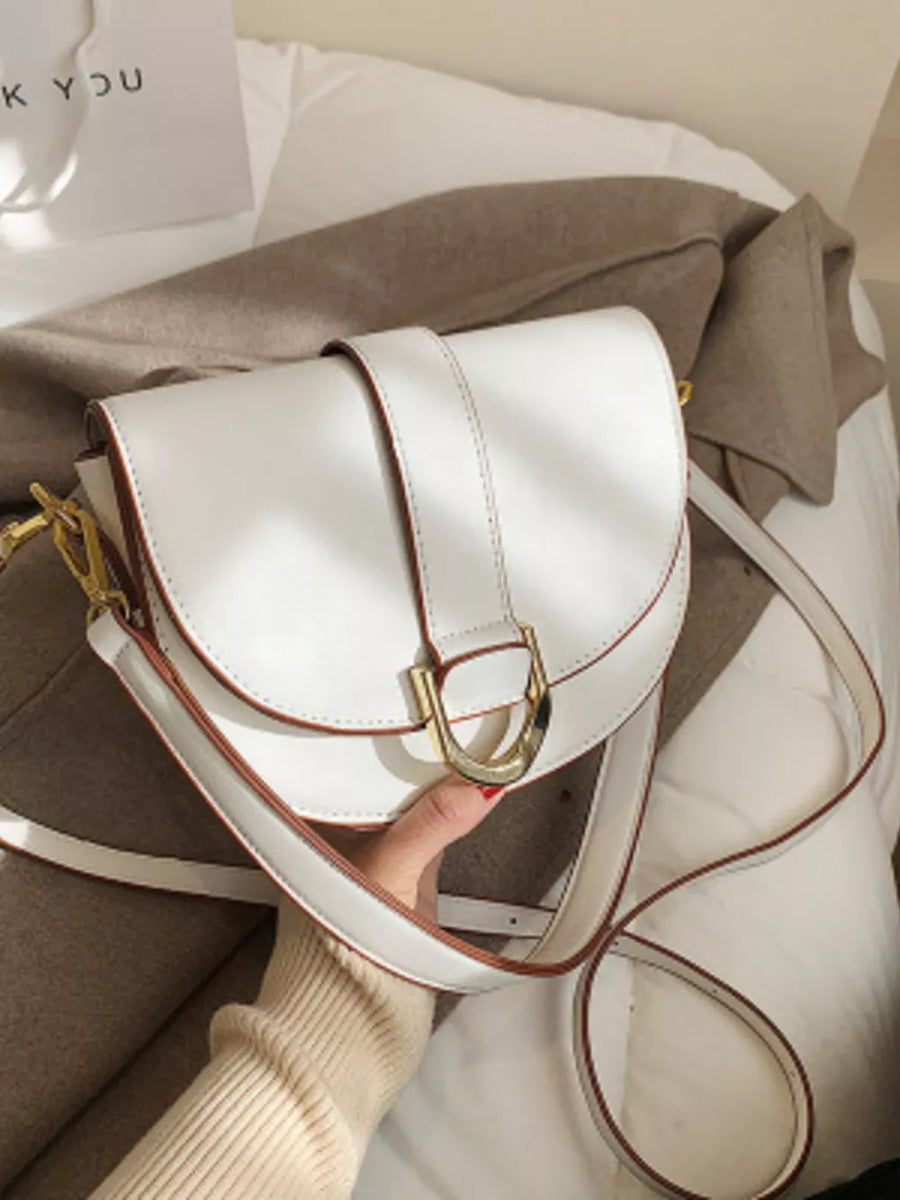 Chic white semi-circular flap crossbody bag with gold buckle detail.