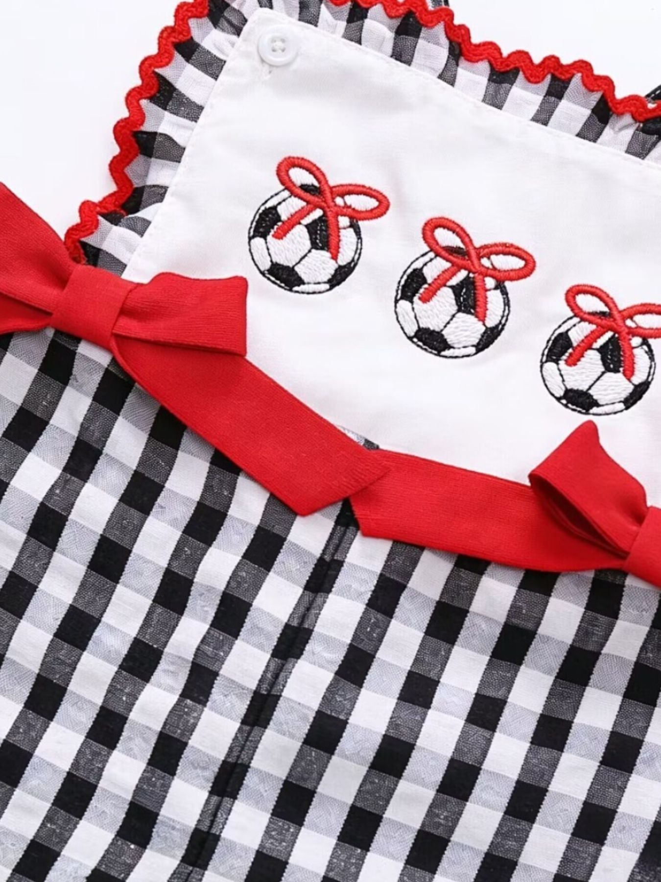Gingham soccer ball embroidered jumpsuit with red bows and trim.