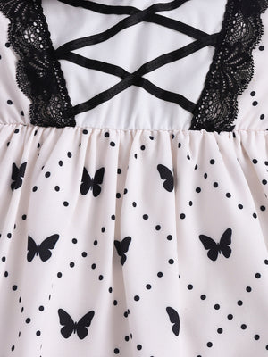 Baby dress with butterfly print, polka dots, black lace trim, and crisscross ribbon detail.