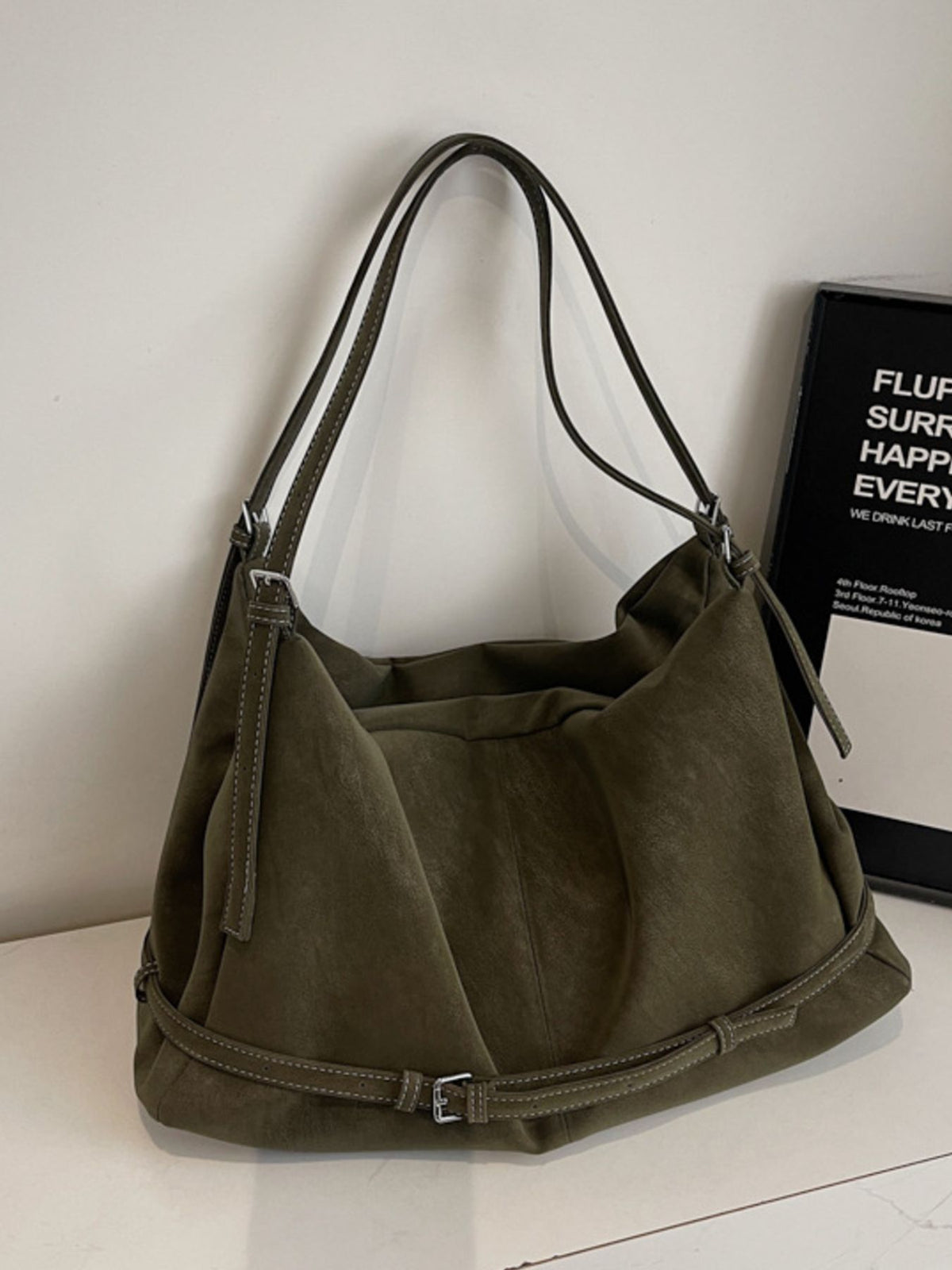 handbag in olive green featuring adjustable straps and slouchy fit