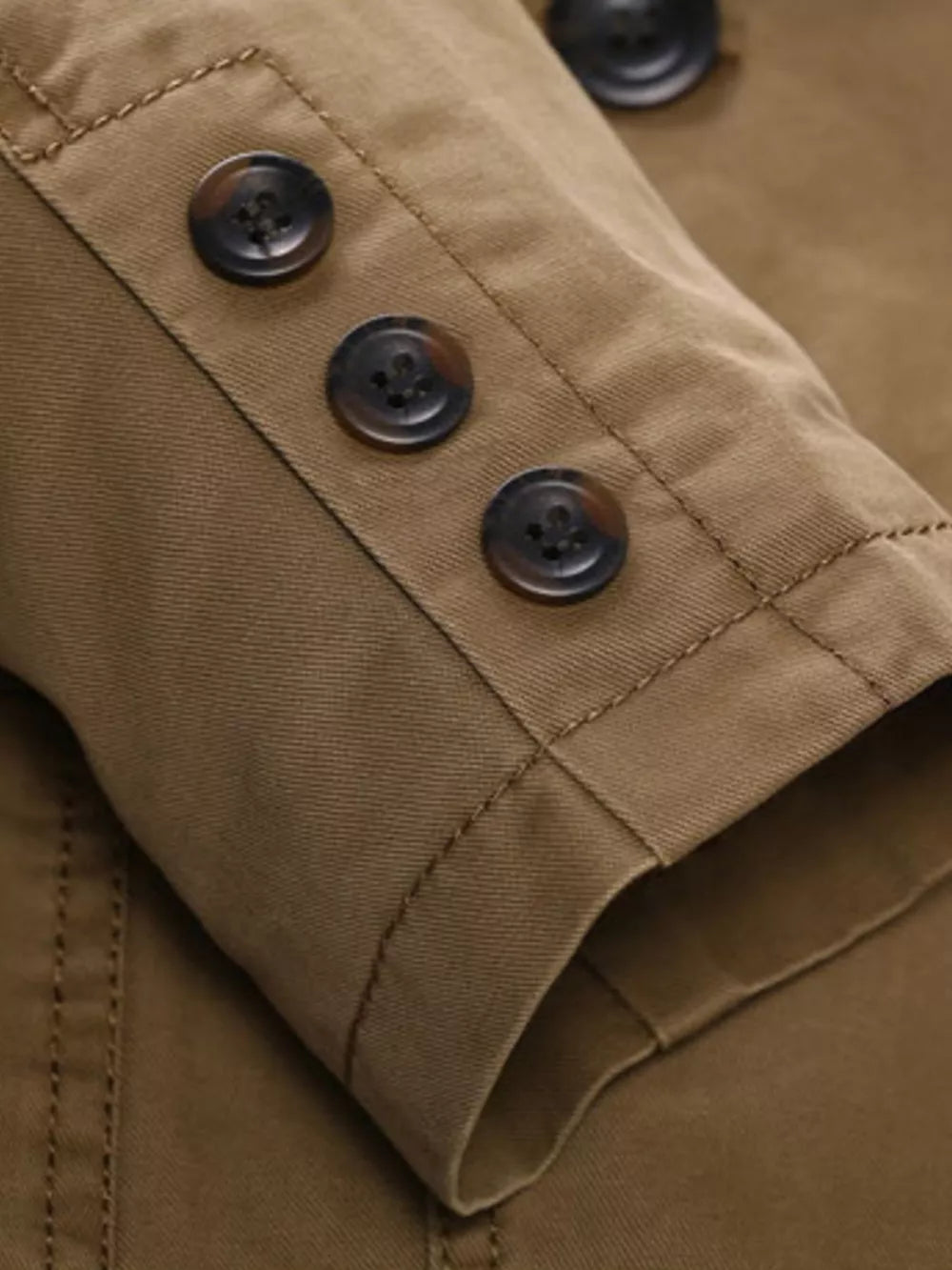 Khaki cotton blazer sleeve detail with three dark buttons and contrast stitching.