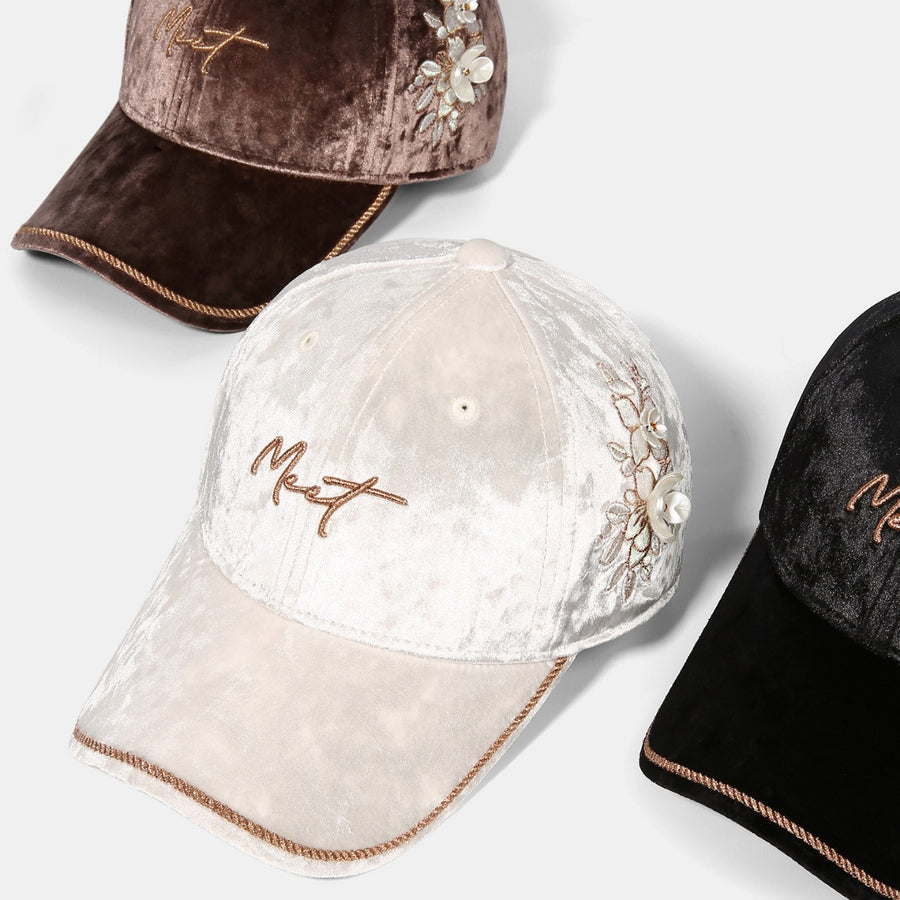 Ivory velvet baseball cap with floral embroidery and braided trim.