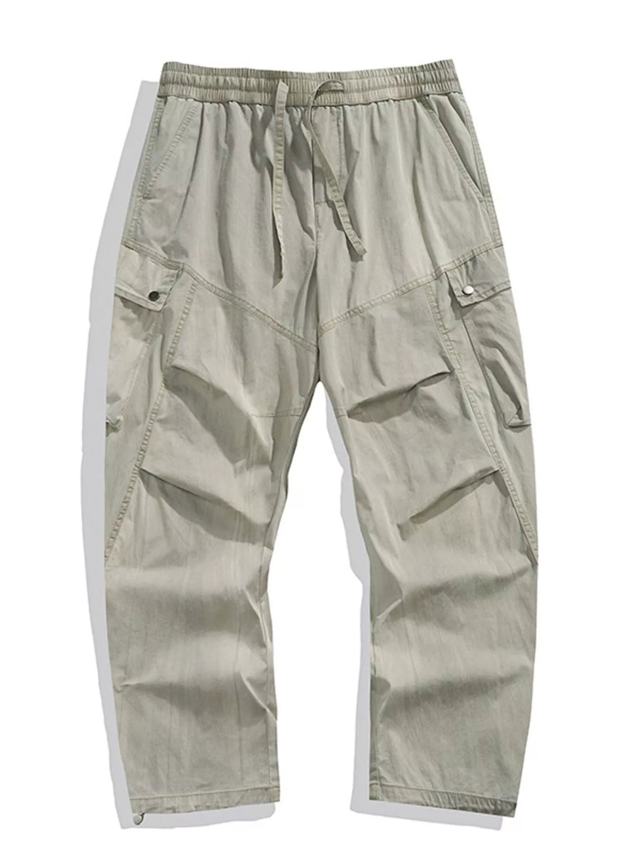 Loose fit khaki cargo pants with drawstring waist and multiple pockets.