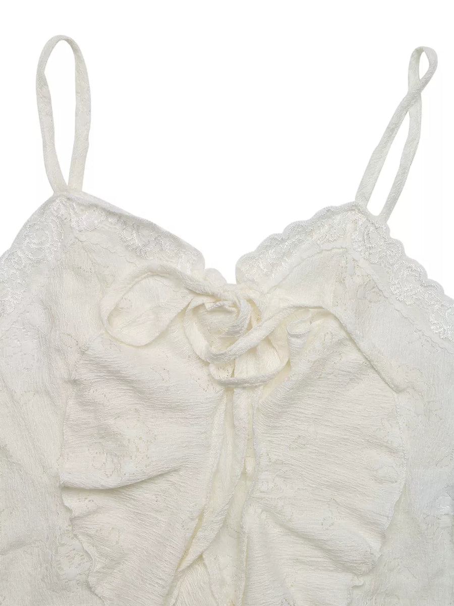 White lace tie-front camisole with ruffled hem and delicate floral pattern.