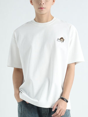 Men's white cotton t-shirt with a small cartoon graphic on the chest.