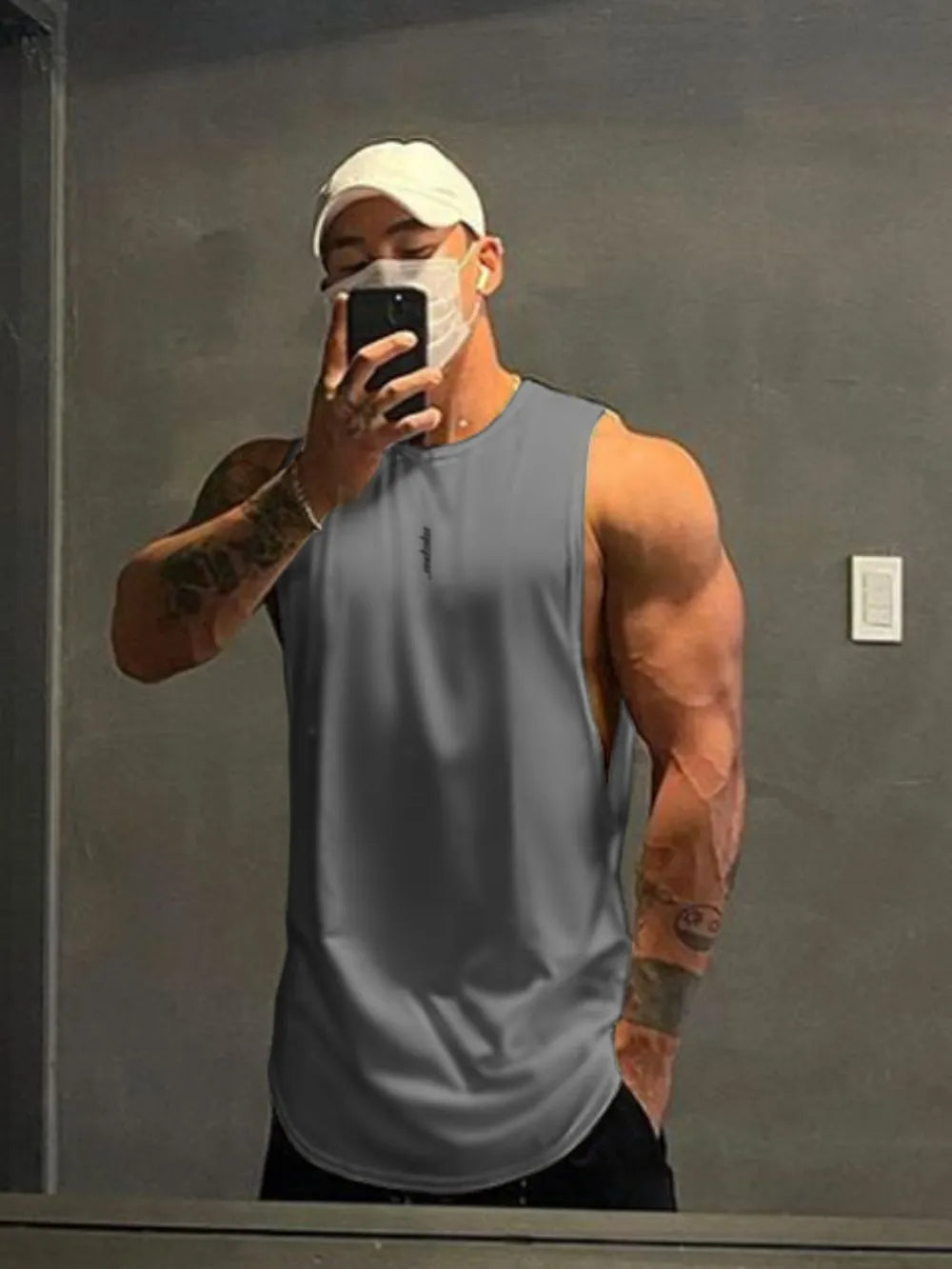 Dark gray performance cut tank top with a curved hem and subtle chest logo.