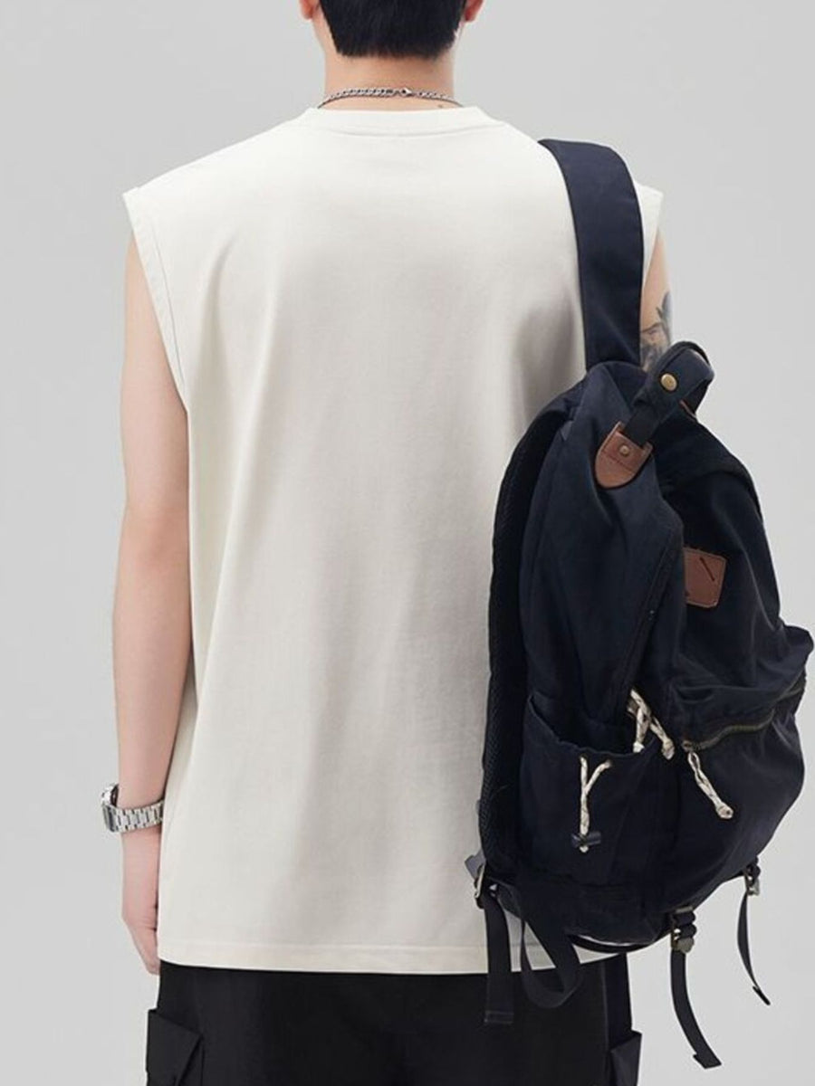 Men's oversized cotton tank top in ivory, shown from the back with a backpack.