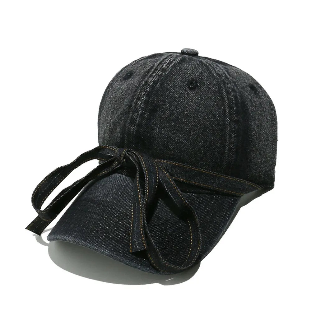 Black denim baseball cap with a bow tie detail.