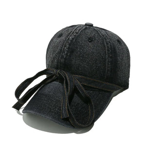 Black denim baseball cap with a bow tie detail.