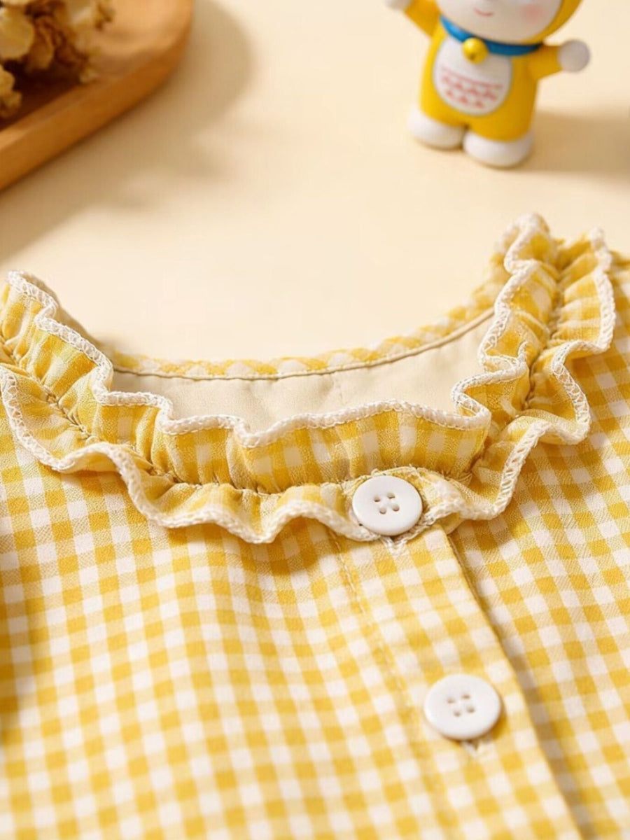 Yellow gingham baby dress with ruffled neckline and button details.
