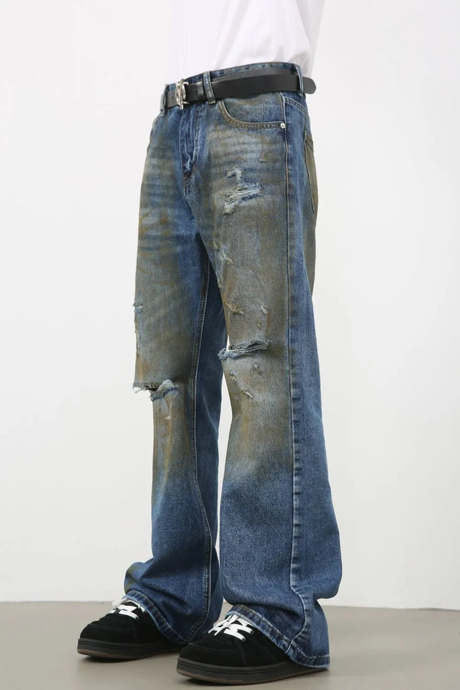 Distressed flare jeans in medium wash denim with patina and ripped details.
