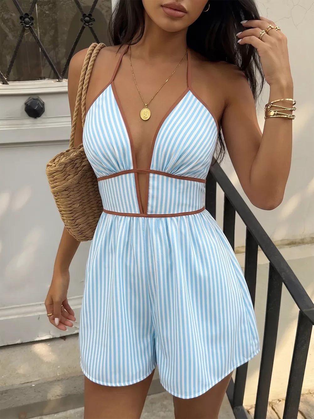 Blue and white striped halter neck romper with brown trim and plunging neckline.
