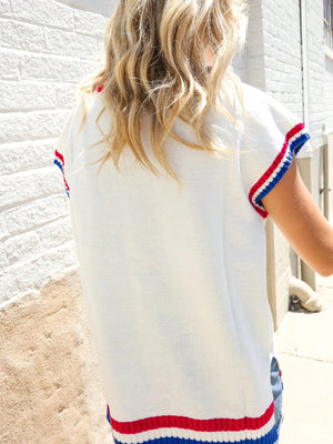 White knit sweater vest with red, white, and blue striped trim on sleeves and hem.