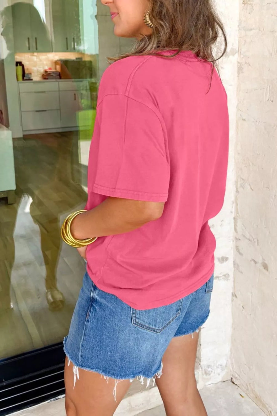 Pink cotton mineral wash tee with short sleeves and a crew neck, styled with denim shorts.
