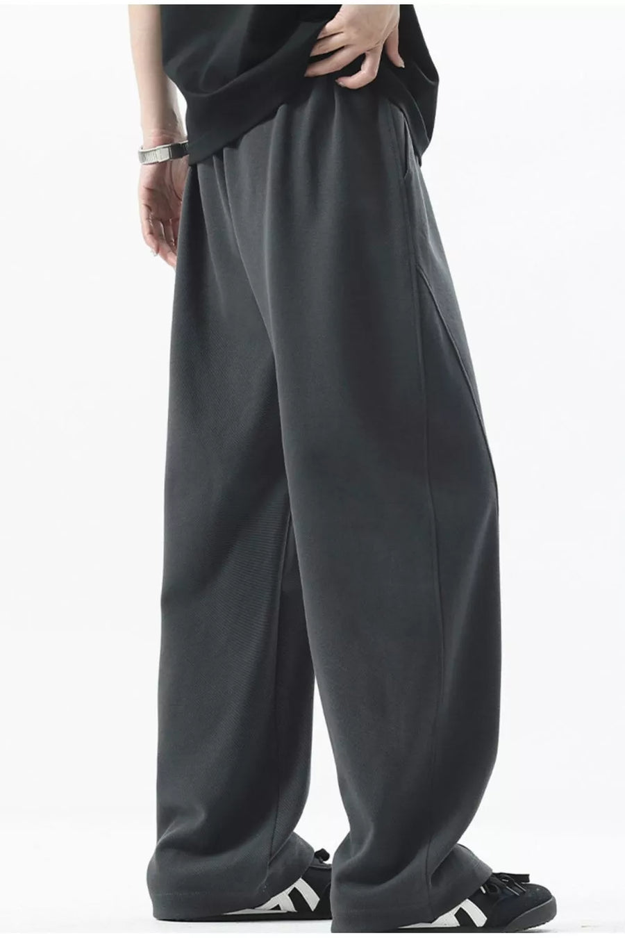 Men's dark gray loose fit sweatpants with side pockets and ribbed texture detail.