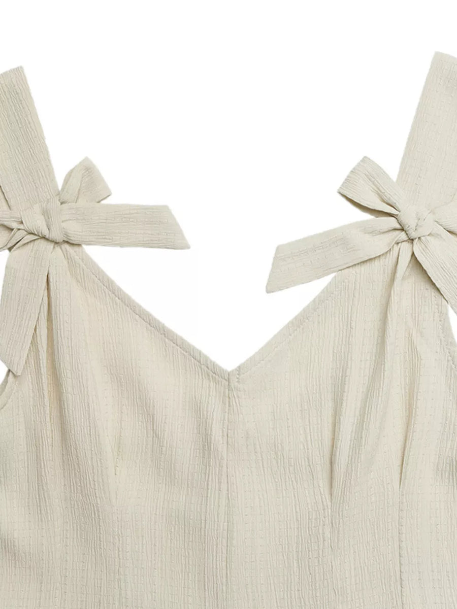 Cream textured romper with V-neck and bowknot shoulder straps