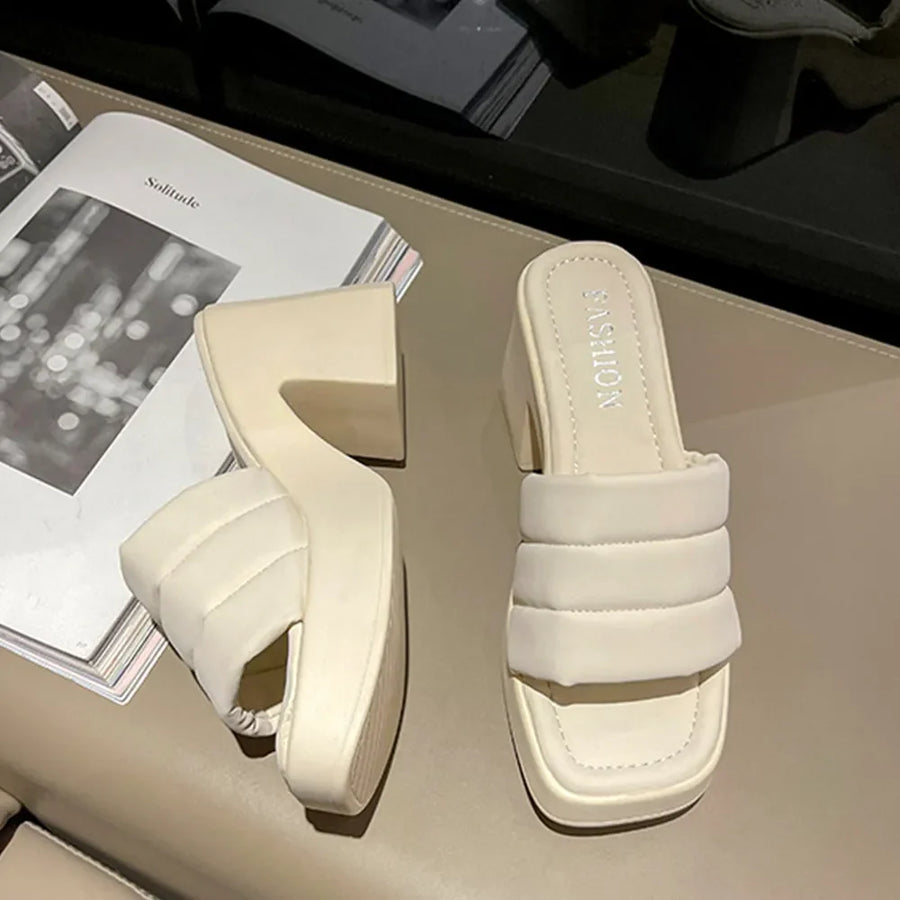 Ivory padded platform mules with a block heel and quilted strap detail.