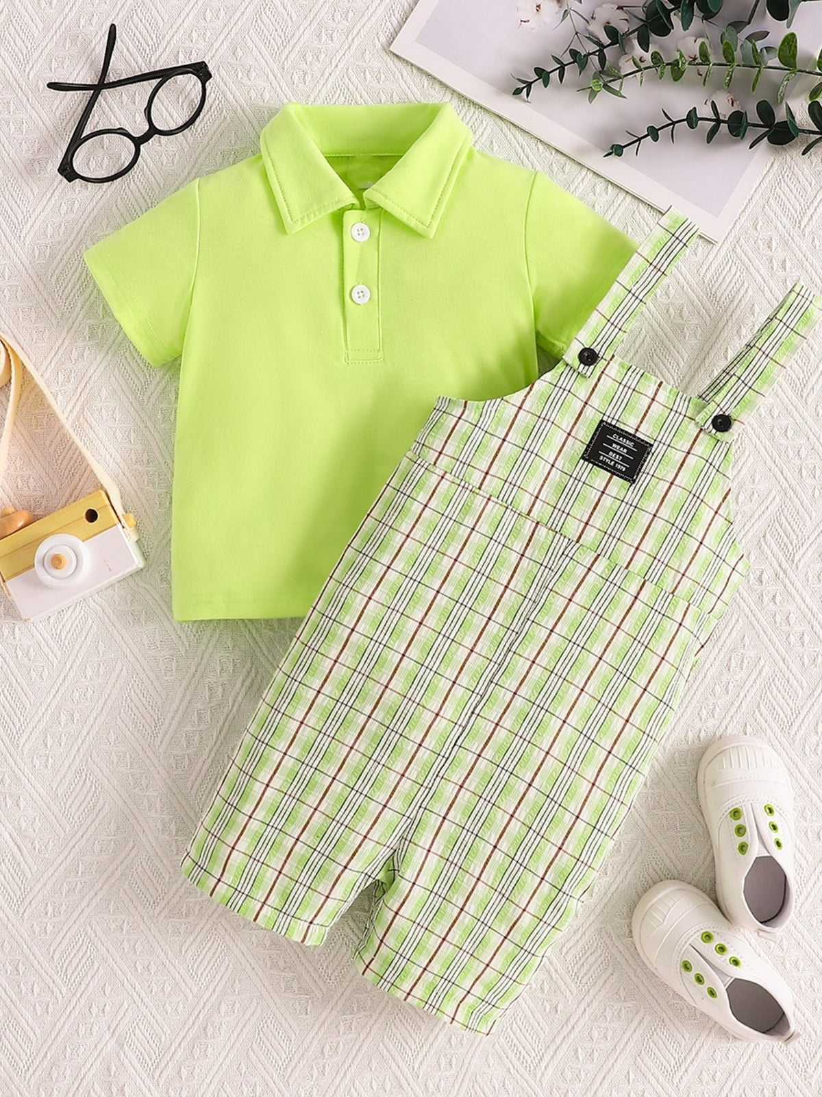 Children's lime green polo shirt and plaid overalls set with adjustable straps.