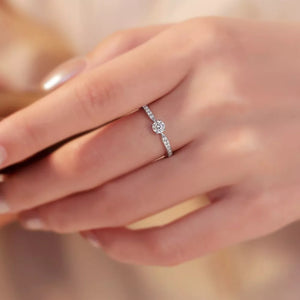Elegant moissanite ring in sterling silver with a brilliant center stone and pave band.