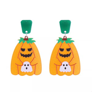 Spooky dangle earrings with orange pumpkins holding white ghosts, green tops.