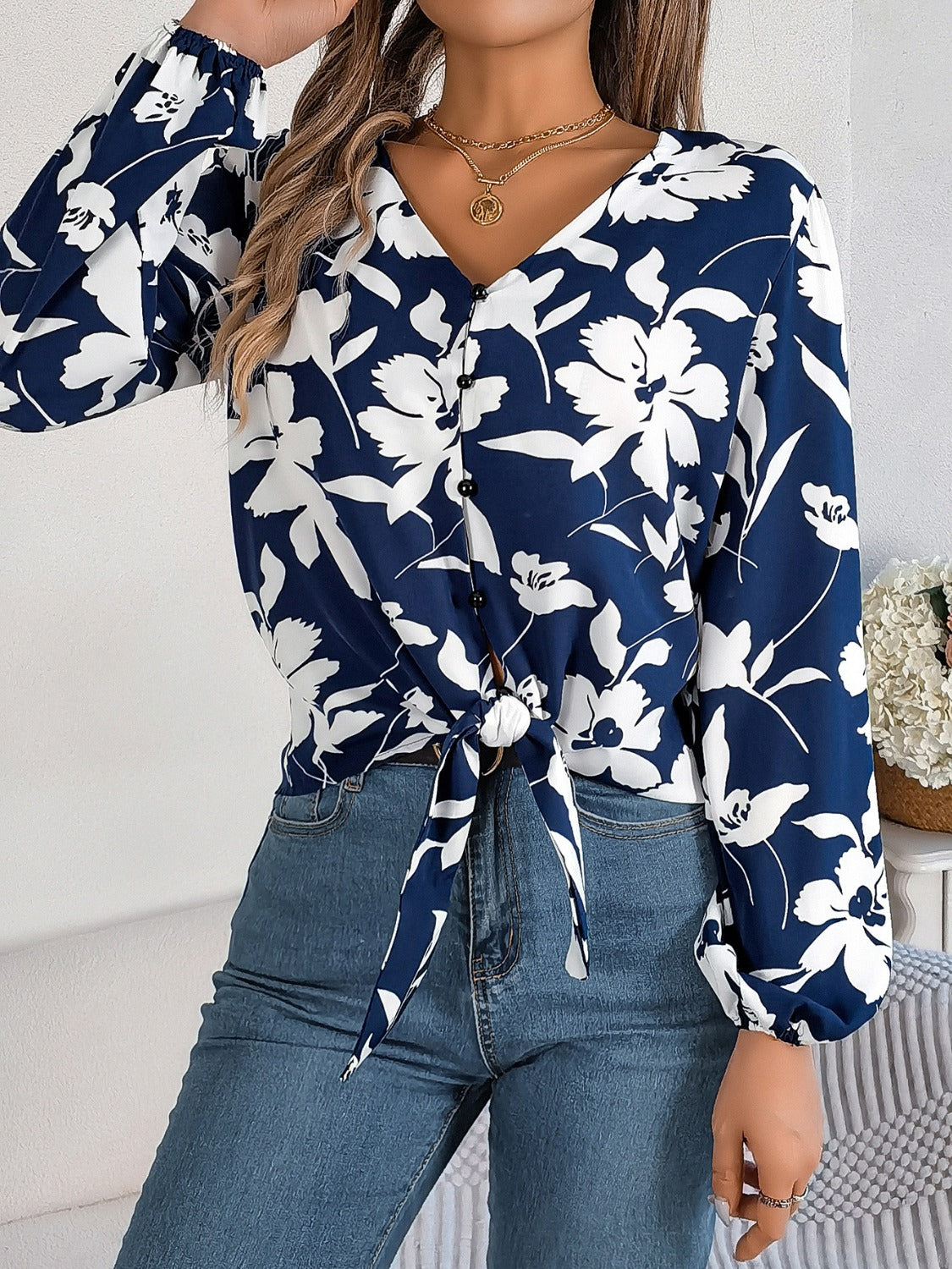 Navy floral knot-front blouse with ruffled cuffs and button detail